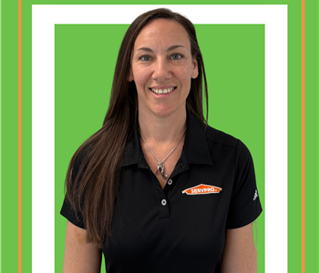 A SERVPRO employee is shown in a black SERVPRO logo shirt